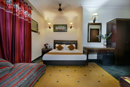 新德里Hotel By Yellow Revels Plum的配有一张床和一张书桌的酒店客房