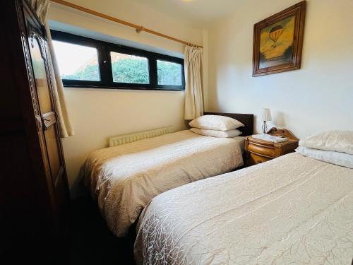 绍斯韦尔The Stables in Southwell的一间卧室设有两张床和窗户。