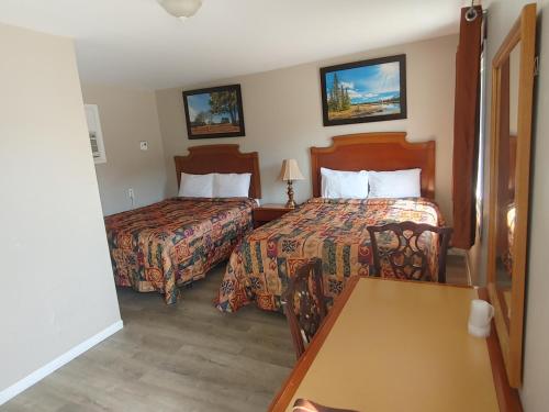 科灵伍德Relax Inn-Collingwood的酒店客房设有两张床和一张桌子。
