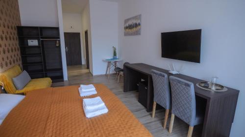 普雷绍夫Premium City Centre Bedrooms的客厅配有床、桌子和电视