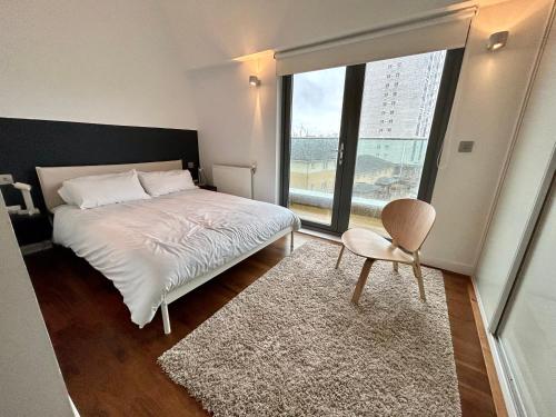 伦敦Stay in Style: Modern 2-Bed In Trendy London Area的一间卧室设有一张床和一个大窗户