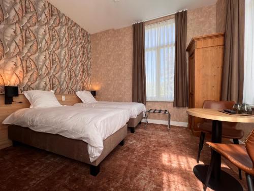 德哈恩肯特拉尔酒店的酒店客房设有两张床和一张桌子。
