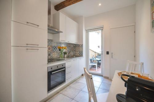 佛罗伦萨San Niccolò Luxury Apartment的厨房配有白色橱柜、桌子和炉灶。