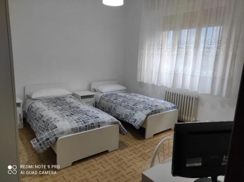 法尔科纳拉·玛里提马Residence Carmen的一间卧室配有两张床和一张带电脑的书桌