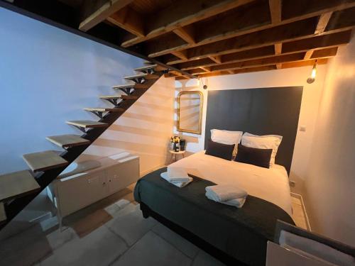 奥特维莱尔Le nid d’Isa的一间卧室配有一张床和一个楼梯间