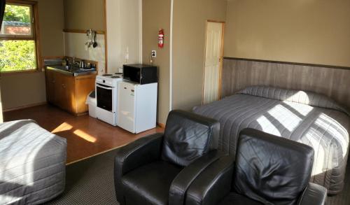 SpringfieldSmylies Accommodation的一间卧室配有一张床、一把椅子和一个水槽