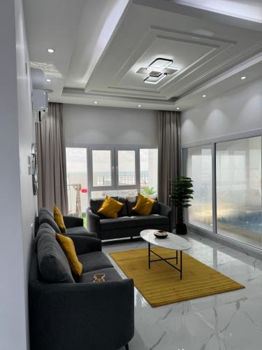 阿夏尔奇亚Sea View Chalet Al Ashkharah的客厅配有两张沙发和一张桌子