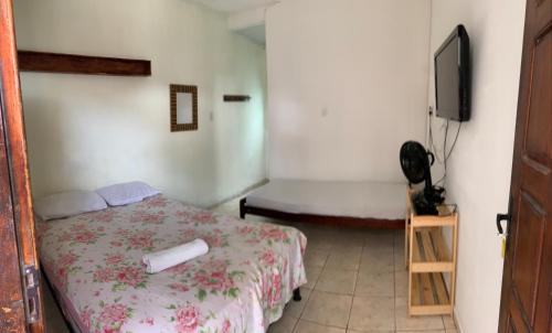 阿拉卡茹Suítes Mar Azul的一间卧室配有一张床和一台电视