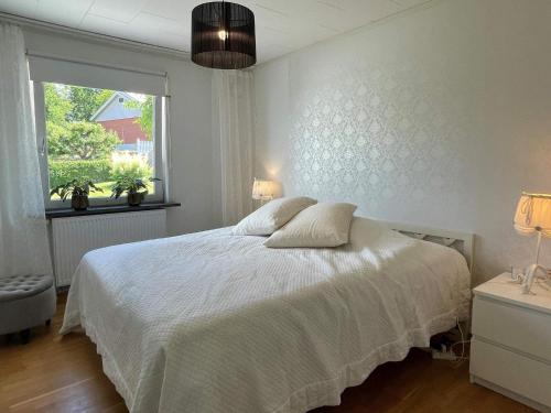 MyggenäsHoliday home MYGGENäS II的卧室配有白色的床和窗户。
