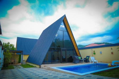 盖贝莱Gabala Twin A Frame Villas的一座房子,设有一个金字塔形屋顶游泳池