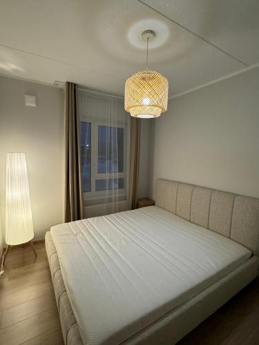 DreiliņiModern 4-Room compact flat with parking in Riga的一间卧室配有一张大床和一个吊灯。