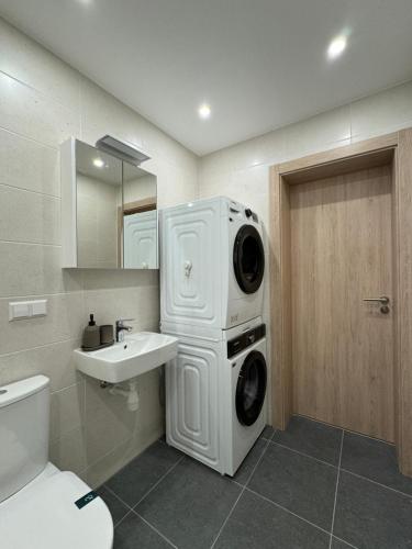 DreiliņiModern 4-Room compact flat with parking in Riga的一个带洗衣机和烘干机的浴室