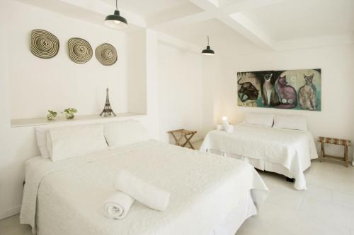 卡塔赫纳Hotel Barahona Cartagena的白色客房的两张床,拥有白色的墙壁