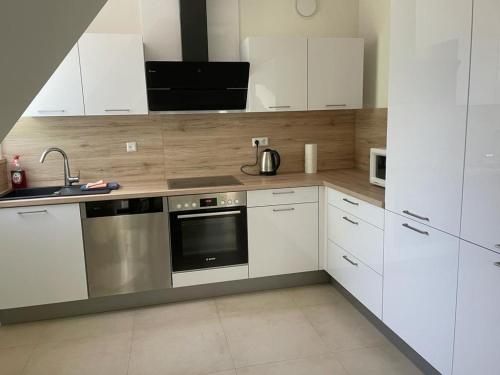 OstercappelnDiner Nord 2的厨房配有白色橱柜和不锈钢烤箱