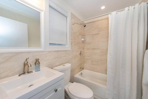 北卑尔根Modern Condo-NYC@Fingertips的浴室配有卫生间、盥洗盆和浴缸。