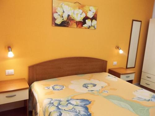 托雷斯佩基亚鲁杰里Villa Mare del Salento的卧室配有一张床,墙上挂有绘画作品