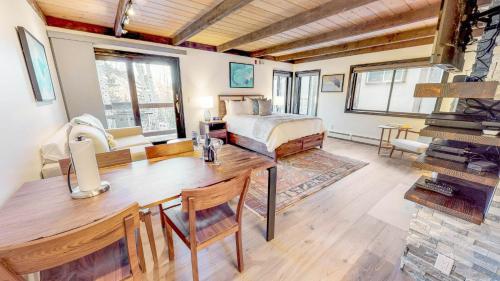 斯诺马斯村Willows - CoralTree Residence Collection的一间卧室配有一张床,另一间用餐室配有桌子