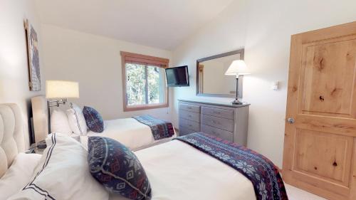 斯诺马斯村Terracehouse - CoralTree Residence Collection的一间卧室配有两张床和镜子