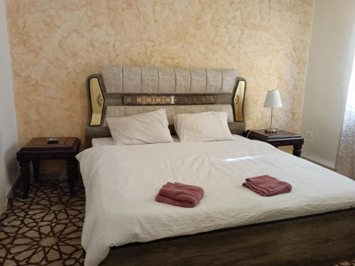 马达巴Jordanian house的一间卧室配有一张大床和两条毛巾