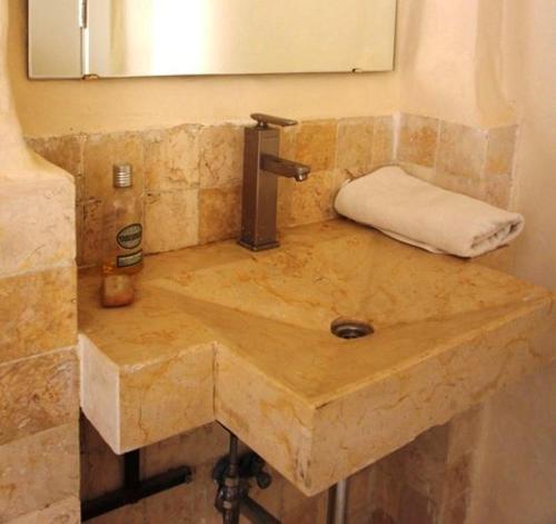 TufailahDana Hotel的浴室内的石水槽和镜子