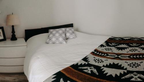 温哥华Small Private Studio at Kitsilano Beach的一张带黑白毯子和枕头的床