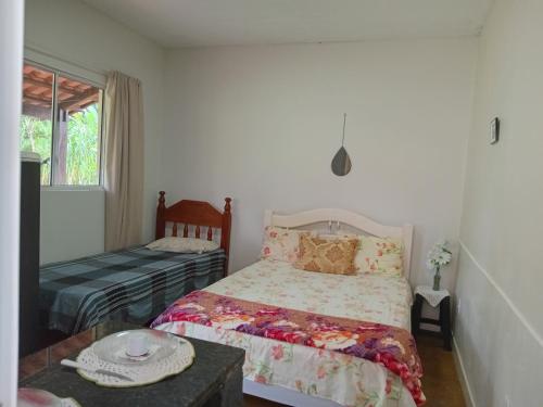 皮雷诺波利斯Recanto São Francisco de Assis的一间卧室配有一张床、一张桌子和一个窗户。
