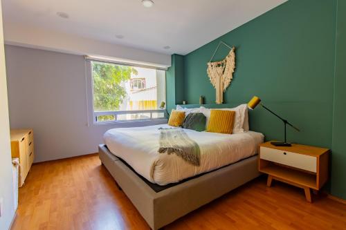 墨西哥城Capitalia - Apartments - Anzures的一间卧室设有一张大床和一个窗户。