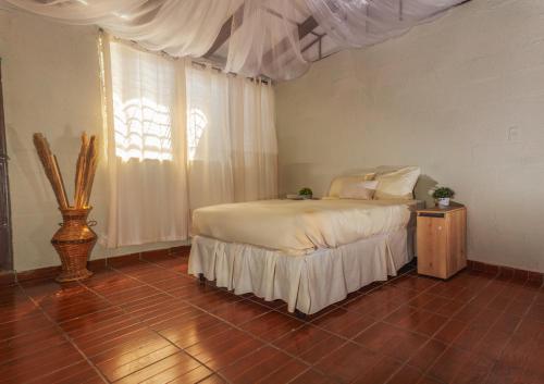 康塞普西翁德阿塔科Hostal Lenha的一间卧室设有一张床和一个大窗户