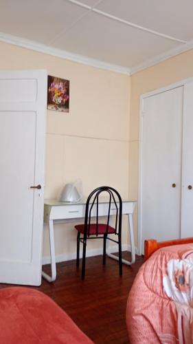 特木科hostal RV的一间卧室配有一张桌子和一张椅子,位于床边