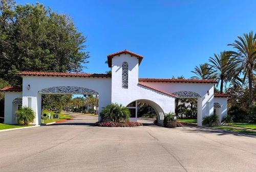 卡尔斯巴德Luxury Villa at Omni La Costa Resort & Spa的一座白色的大建筑,有大门和棕榈树