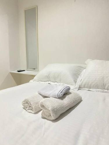 卡塔赫纳Apartamento cómodo cerca al aeropuerto的白色的床,上面有毛巾