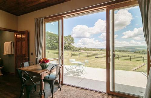 NundaLetchworth Farm Guesthouses的一间设有桌子和大型滑动玻璃门的房间