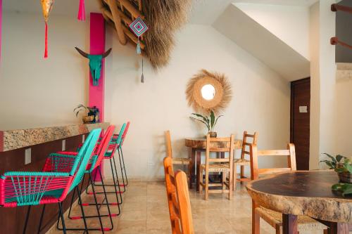 萨尤利塔Nuiya Hoteles Centro的用餐室配有五颜六色的椅子和桌子