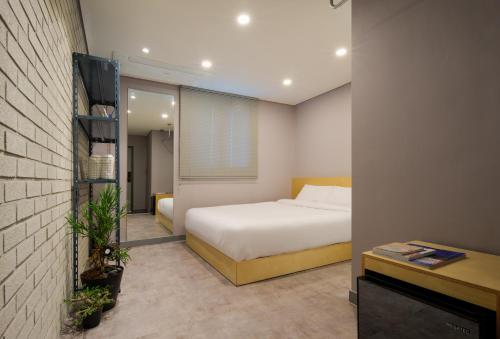 江陵市Markers Hostel的一间酒店客房,配有一张床和一台电视