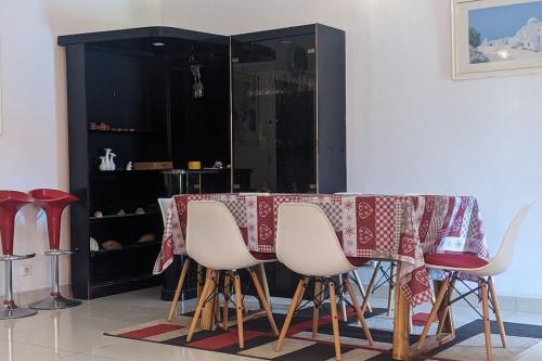 洛美Élégante villa avec jardin+bar的餐桌、白色椅子和黑色橱柜