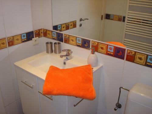 布鲁塞尔阿兰住宿加早餐酒店的浴室设有水槽上的橙色毛巾
