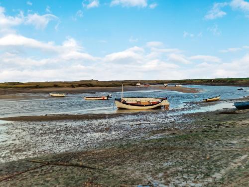 赫彻姆High Tide House的一群坐在海滩上水中的船