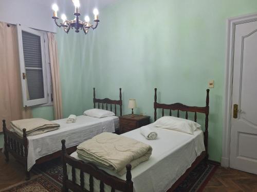 派桑杜Casona Harguindeguy的一间卧室配有两张床和吊灯。