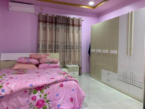 FuvahmulahSaina Dive Residence - Fuvahmulah, Maldives的一间卧室配有粉红色的床铺和粉红色的床单
