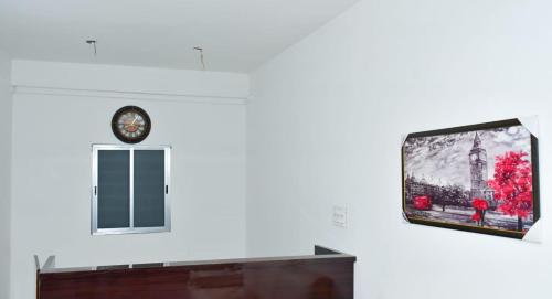 DālkolaDESIRE LODGE的墙上的平板电视,带时钟
