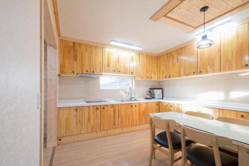 济州市나무집 게스트하우스的厨房配有木制橱柜和桌椅