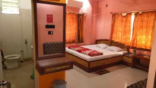 迪卡Hotel Sunny New Digha Near Sea Beach View Point - Couple Friendly的一间小卧室,配有一张床和镜子