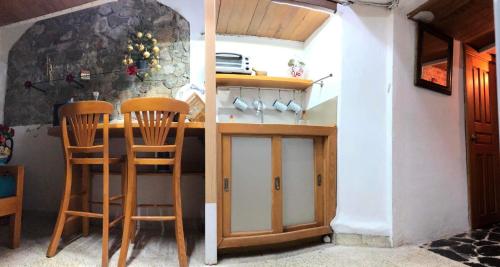 塔斯科·德·阿拉尔孔Casita la adornada的厨房配有柜台和2把木椅