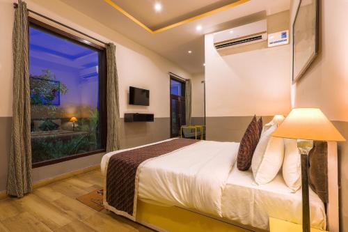加尔加Corbett Wild Resorts & Spa的一间卧室设有一张床和一个大窗户
