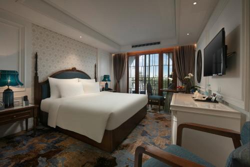 河内The Oriental Jade Hotel的酒店客房设有一张大床和一张书桌。