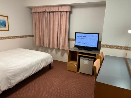 御殿场市Hotel Alpha-One Gotemba Inter的配有一张床和一台平面电视的酒店客房