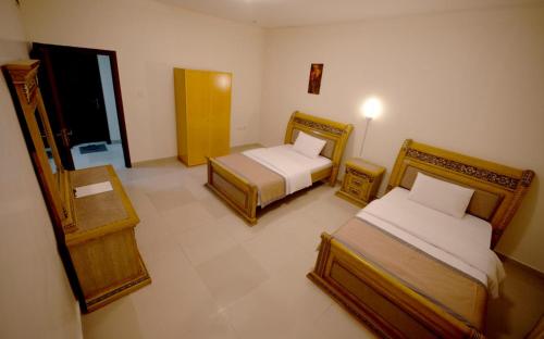 阿吉曼AL MARJAN FURNISHED APARTMENTS的酒店客房设有两张床和一个阳台。