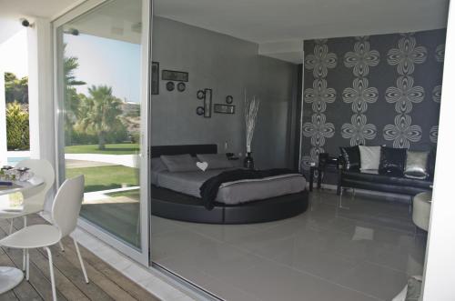 卡拉塔斯Reveli Estate的一间卧室设有一张床和一个滑动玻璃门