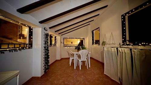 塞埃欣Casa Rural El Alcázar - Cehegín的一间配备有白色椅子和桌子的用餐室