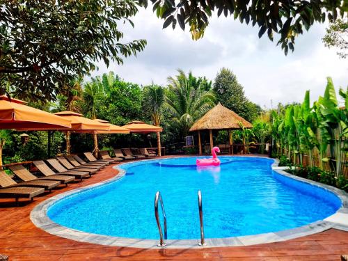 芹苴Bamboo Eco Village的度假酒店内带粉红色火烈鸟的游泳池
